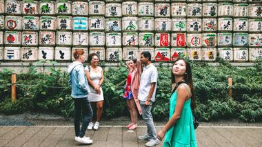 Travellers admiring the sake barrels on route to the Meiji Shrine, Tokyo, Japan