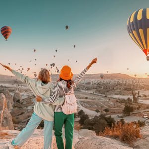 Travellers watch hot air balloons rise over Cappadocia at sunrise on the Contiki Best of Turkey Tour