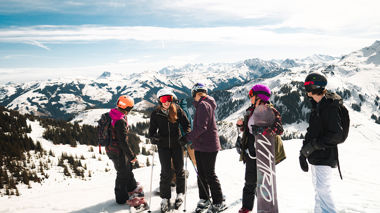 Travellers with skis and snowboards on the slopes, Hopfgarten, Austria