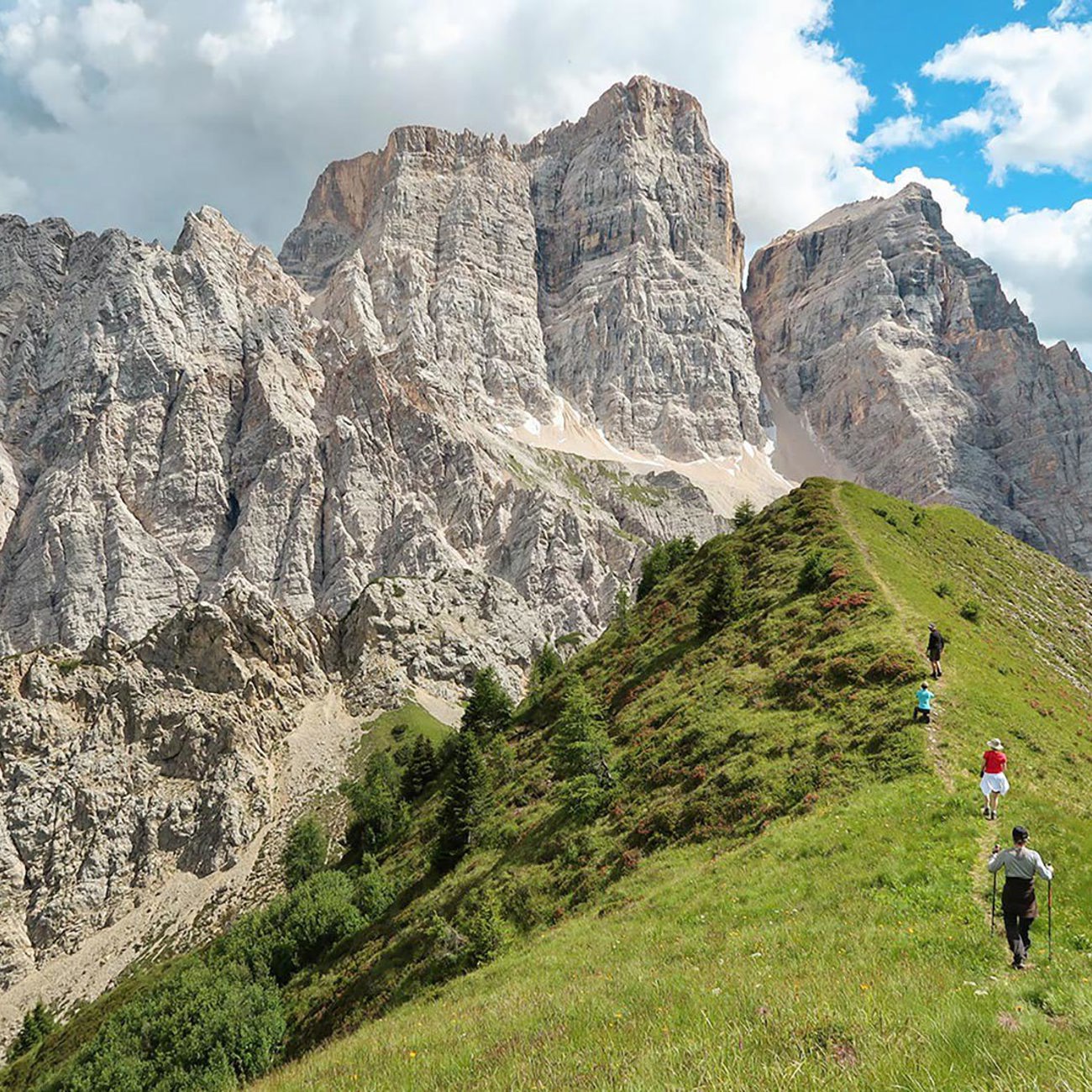 Travellers walking on a verge looking at a mountain range in Dolomites, Italy