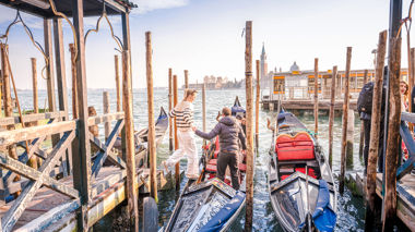 A traveller being helped onto a gondola in Venice, Italy