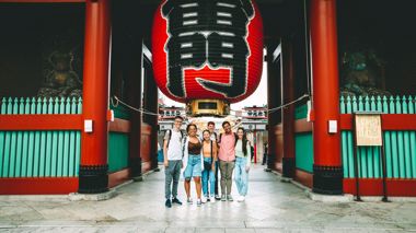 Travellers posing for a picture under the red lantern at Sensoji Temple, Japan