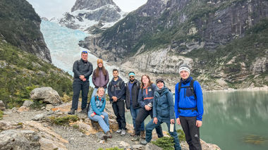 A group of travellers standing in front of glaciers in Puerto Natales, Patagonia