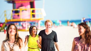 Travellers Strolling Across Beach in Miami, USA