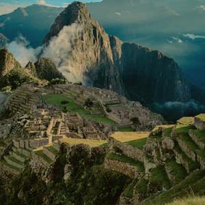 Panoramic aerial view of Machu Picchu ancient Inca citadel and terraces with cloud-covered Huayna Picchu mountain in the Sacred Valley Peru - Contiki Best of Peru Tour