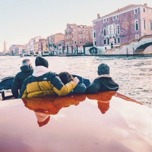 Travellers cruising through Venice by water taxi - Contiki Barcelona to London Quest Tour