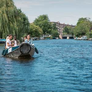 Contiki travellers cruise along Amsterdam's canals in a small boat on the European Encounter Tour
