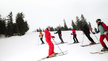 Travellers and instructor during a guided ski tour of the mountain in Hopfgarten, Austria