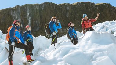 Five travellers standing on Fox Glacier surrounded by snow in Fox Glacier, New Zealand