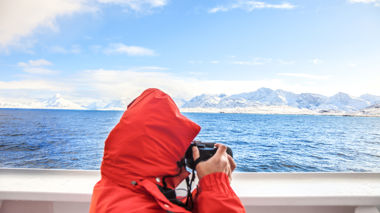 Traveller taking a photo on a cruise in Hurtigruten, Norway