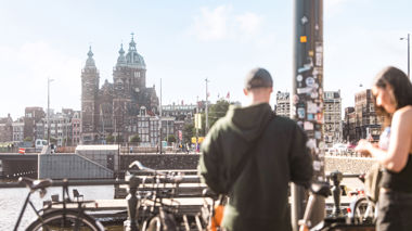 Travellers stood next to bikes in Amsterdam, Netherlands