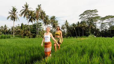 Two travellers walking together in a rice field in Ubud, Indonesia