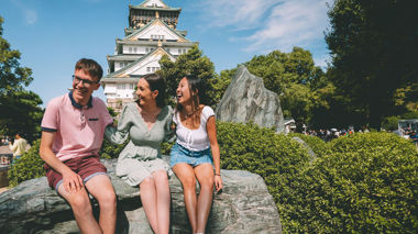 Travellers Relaxing Outside Osaka Castle, Japan