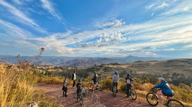 Travellers riding mountain bikes along a path in Cusco, Peru