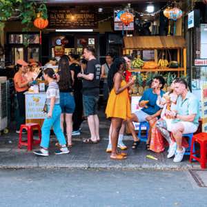Travellers eating bánh mì outside the famous Bánh Mì Phượng shop in Hội An Vietnam - Contiki Vietnam Tour