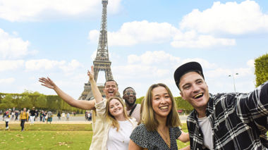 Travellers posing in front of the Eiffel Tower in Paris, France