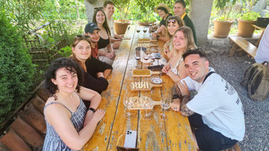 Travellers sat at picnic table with wine and food boards, Sagaredjo, Georgia