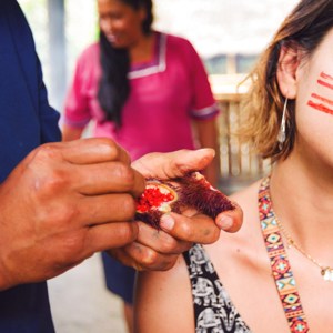 Traveller having local face paint applied in Tena, Ecuador