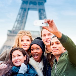 Travellers pose for a selfie in front of the Eiffel Tower, in Paris, France