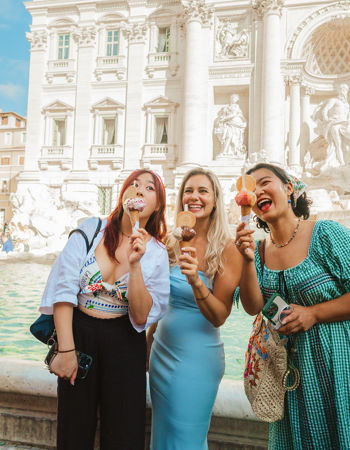 Travellers holding gelato in front of the Trevi fountain, Rome, Italy