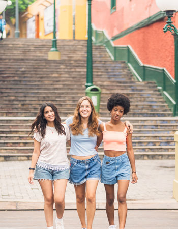 Three travellers walking across a bridge in Lima, Peru