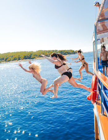 Travellers Jumping into the sea from the sail boat en route to Hvar, Croatia