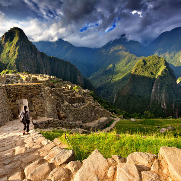 Female tourist descending stairs overlooking Machu Picchu, Peru
