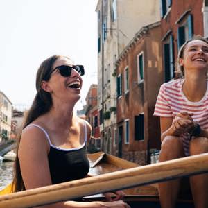 Travellers riding a gondola through the canals of Venice, Italy, during Contiki's Best of Italy Tour