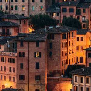 Historic Tuscan town at sunset, featuring terracotta rooftops and traditional Italian architecture on the Contikii Tuscan Escape Tour