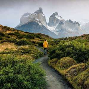 Traveller hiking through Patagonia with dramatic mountain peaks on the Contiki Active Patagonia Tour