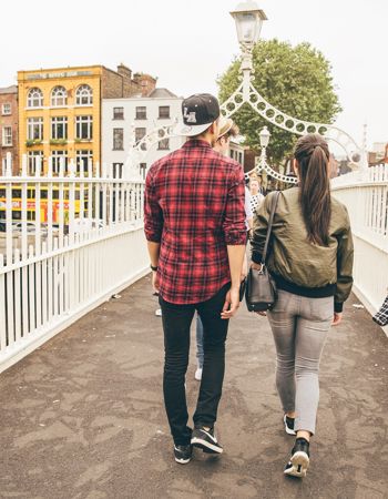 Travellers walking over Ha'penny bridge in Dublin, Ireland