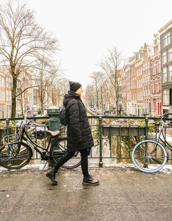 Traveller walking over a bridge during winter in Amsterdam, Netherlands