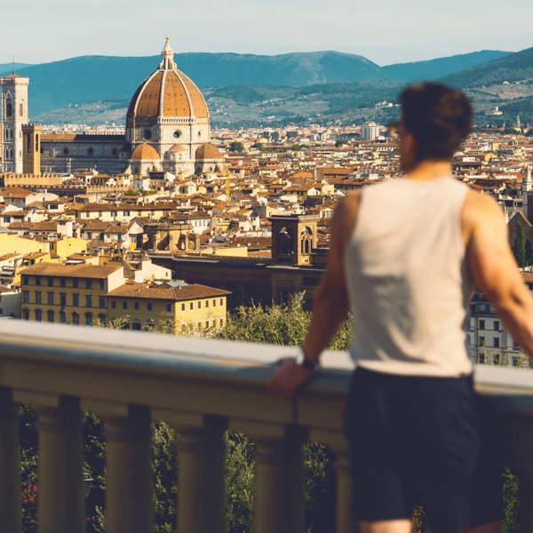 Traveller at Piazzale Michelangelo overlooking the Florence skyline with Brunelleschi's Duomo and Campanile in Tuscany Italy - Contiki European Discovery Tour