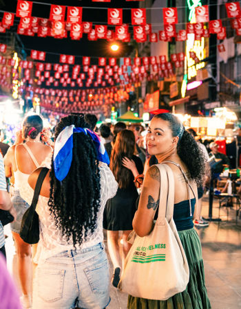 Traveller walking on Khao San road, looking back at camera, Bangkok, Thailand