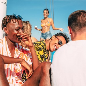 Group of travellers laughing and smiling on the coast of Greece