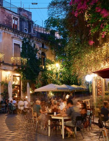 A busy street lit up by fairy lights in Catania, Italy