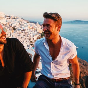 Friends enjoying sunset views over Santorini's whitewashed villages on Contiki's Athens to Santorini 35 to 45 Tour