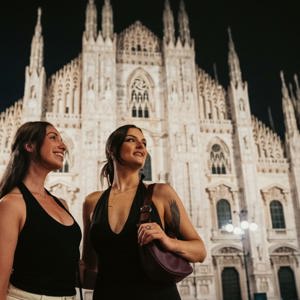 Two girls admiring Milan Cathedral (Duomo di Milano) at night - Contiki Paris to Rome by Train Tour