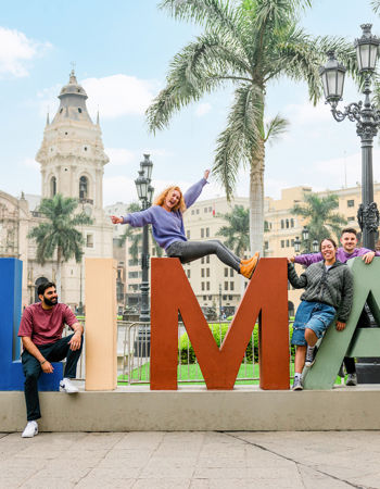 Travellers posing on Lima letters sign, Peru