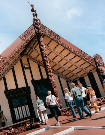 A group of travellers walking into the Marae Special Stay in Rotorua, New Zealand
