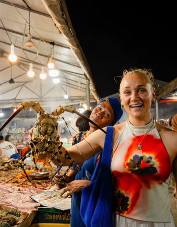 Traveller holding an ornate spiny lobster at a market in Malaysia