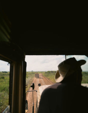 Traveller sitting in safari truck on a dirt road in South Africa