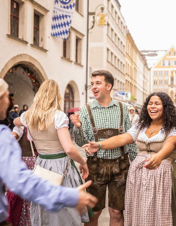 Travellers outside a beer hall, wearing their dirndls in Munich Germany