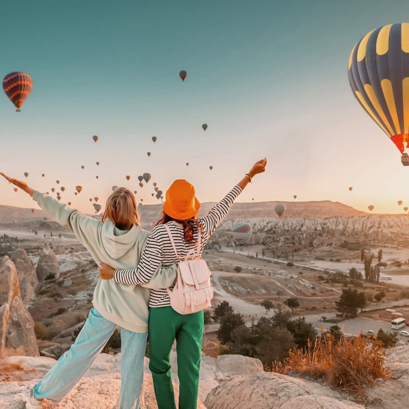 Travellers watch hot air balloons rise over Cappadocia at sunrise on the Contiki Best of Turkey Tour