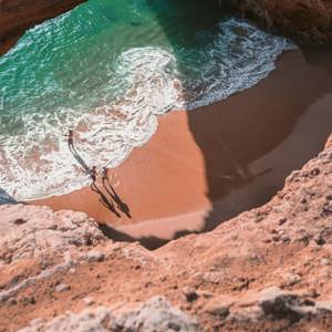 Contiki travellers exploring Benagil Cave on Portugal’s Algarve coast, enjoying the secluded beach and turquoise waters on the Madrid to Lisbon Tour