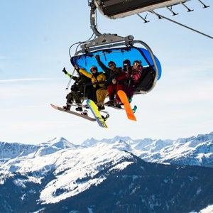 Travellers riding a chairlift with panoramic views of the Austrian Alps on the Contiki Ski Austria 35 to 45 Tour
