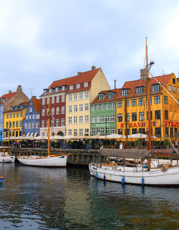 A landscape view of colourful houses and boats along a river in Copenhagen, Denmark