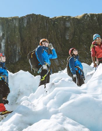 Five travellers standing on Fox Glacier surrounded by snow in Fox Glacier, New Zealand