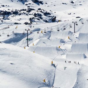 Aerial view of skiers and snowboarders on the ski runs with chairlifts and snow jumps n New Zealand - Contiki Ski NZ Tour
