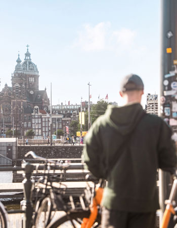 Travellers stood next to bikes in Amsterdam, Netherlands